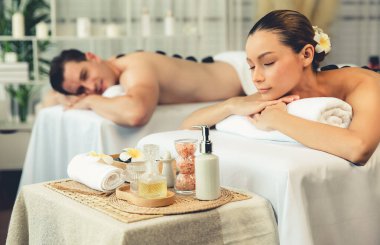 Lüks tatil köyündeki kaplıca salonunda sıcak taş masajı. Gündüz dinginliği ortam, mutlu çift müşterileri bazalt taşı masajının keyfini çıkarıyor. Rahatlatıcı bir sıcaklıkla vücudun üzerinde süzülüyorlar. Sessiz.