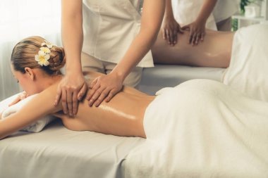 Kafkas çift müşterisi stres önleyici spa masajının keyfini çıkarıyor ve lüks otel veya oteldeki gündüz açık hava ortamında güzellik teniyle eğleniyor. Sessiz.