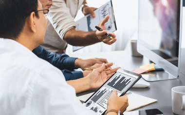 Veri analistleri ofis çalışanlarından oluşan bir ekip, tablet kullanarak finansal, trend ve pazarlama verilerini analiz etmek için iş istihbaratı BI gösterge paneli üzerinde işbirliği yapmaktadır. BI teknolojisi ve veri analizi kavramı. Tedbirli