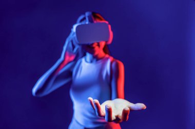 Akıllı Kadın, metaevrene bağlı, fütürist siber uzay topluluğu teknolojisiyle çevrili, ışıklı VR kulaklık takıyor. Zarif bir kadın elde tutulan sanal objeyi kullanır. Halüsinasyon.