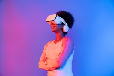 Profil, VR gözlük takan genç ve güzel Afrikalıların mavi ve pembe neon ışıklı arkaplanda izole olduğunu düşünüyor. Teknoloji ve dijital yenilik 3 boyutlu hologram gramında. Entrika.