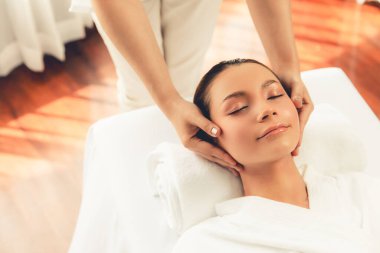 Kafkasyalı kadın stres önleyici kafa masajından ve lüks tatil beldesi ya da otel spa salonundaki modern ışık ortamında yüz güzelliği eğlencelerini şımartmaktan hoşlanıyor. Sessiz.