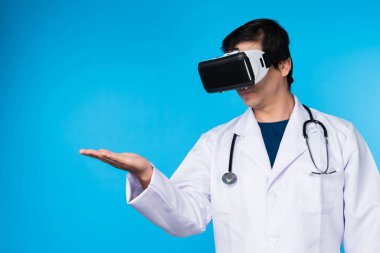 VR kulaklık takan zeki doktor analitik tıp araştırmaları içeren verileri birleştirmeye çalışıyor. Mavi arka plan fütüristik teknoloji hologramı sanal gerçeklik meta dünyası. Entrika.