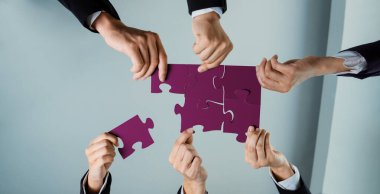 Üst düzey panorama panorama iş adamlarının masa üzerinde yapboz yapbozu yapmaları, iş ortaklığını ve insan kaynakları için kolektif takım çalışmasını ve iş arayan geçmişini sembolize ediyor. Kurnaz.