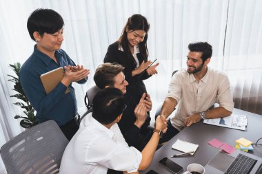 Çeşitli ofis çalışanları stratejik iş pazarlama toplantısı üzerine anlaşma yaptıktan sonra el sıkışıyor. Takım çalışması ve olumlu tutum verimli ve destekleyici bir iş yeri yaratır. Tedbirli
