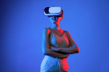 Akıllı kadın, metaevrene bağlı, fütürist siber uzay teknolojisine sahip VR kulaklık takıyor. Zarif kadın sanal alana bakarken kendine güvenerek poz veriyor. Halüsinasyon.