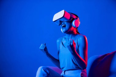 Akıllı Kadın, etrafı neon ışıklı kulaklıkla çevrili bir kanepede oturuyor. Meta-evren, fütürist siber uzay teknolojisini birbirine bağlayan VR kulaklık takıyor. Neşeli hareketli ve mutlu yüzlü bir film izliyor. Halüsinasyon.