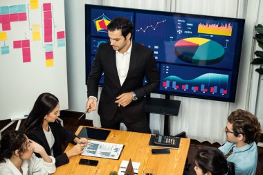 Toplantı masasındaki finansal veri raporlarını analiz eden çeşitli iş analist gruplarının geniş görüşü. İş zekası analizine göre çizelge ve grafik paneli. Çok titiz.
