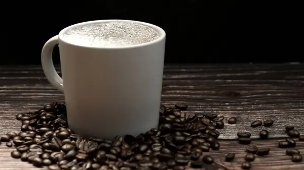 stock image Coffee machine filling aromatic hot coffee in to cup with black background. Hot coffee or espresso is pouring into white coffee cup falling into boiled water with separated black backdrop. Comestible.