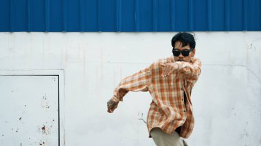 İspanyol komedi koreografı hip hop tarzında dans ediyor. Genç mutlu break dansçı B-boy dansı yapıyor. Sokak dansı yapan komik adamın hareket çekimi. Açık hava sporu 2024. Modern dans. hiphop.