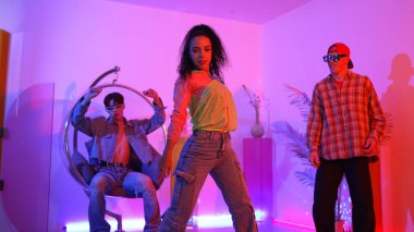 Çekici mutlu dansçı kameraya bakarken zeki kadın neon ışıkla kafiyeli hareket ediyor. Profesyonel İspanyol şarkıcı çeşitli arkadaşlarıyla renkli kıyafetler giyerken break dans yapıyor. Mutluluk.