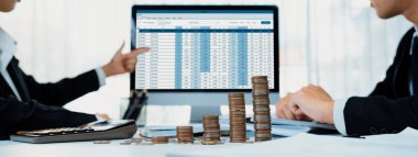 Kurumsal muhasebeci, vergi iadelerini hesaplamak ve maksimuma çıkarmak için dizüstü bilgisayar üzerinde muhasebe yazılımı kullanır ve Panorama 'daki iş yatırım yığını madeni para konseptiyle finansal performansı artırır. Kurnaz.