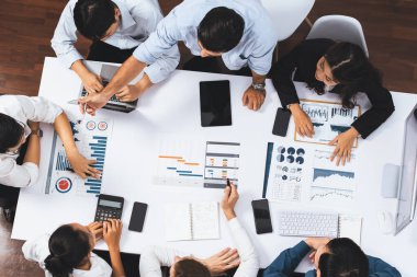 Üst görünüm proje yöneticisi proje yönetimi yazılımı kullanarak ekip ile iletişim kurar ve işbirliği yapar, proje görevinin ilerlemesini izler ve toplantı masasında program planı yapar. Tedbirli