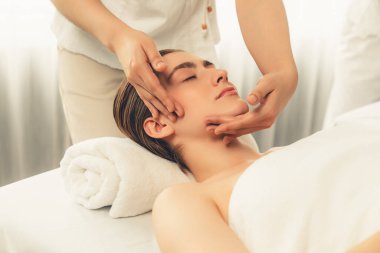 Kafkasyalı kadın stres önleyici kafa masajından ve lüks tatil beldesi ya da otel spa salonundaki modern ışık ortamında yüz güzelliği eğlencelerini şımartmaktan hoşlanıyor. Sessiz.