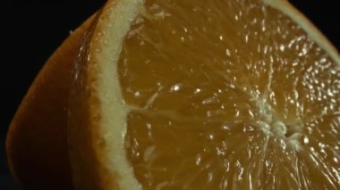 Portakal diliminin bir makrografi görüntüsü, parlak, izole edilmiş bir arkaplan üzerine yerleştirilmiş, narenciye cazibesinin görsel bir başyapıtı olarak gözler önüne seriliyor. Siyah arkaplanlı bir dilim portakal. Geliştirilebilir.