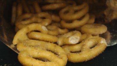 Dağılmış tuzlu krakeri bir paketin içinde saklayın. Hareket eden kamerayla yerleştirilmiş makro atıştırmalık. Stüdyo makro atıştırmalık ve baharat tozu. Tasarım ve baskı için alanı kopyala. Pabulum.