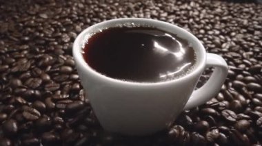 Kahve çekirdeğini yaklaştır ve kahve çekirdeği yığınıyla birlikte sıcak espresso 'ya bırak. Makro taze kavrulmuş fasulye aromatik dumanla bardağa düşüyor. Ağır çekim. Organik kahve tohumu kavramı. Geliştirilebilir.