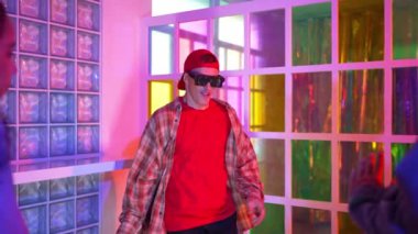 Kafkas dansçısı dans ederken çeşitli arkadaşları gece kulübünde neon ışıkta ayak seslerine bakıyor. Çoklu etnik kökenli hipsterin serbest stil müziğe geçişi ve mutlu bir adamın kameraya bakışıyla. Mutluluk.