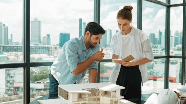 Yetenekli mimar mühendis takımı ev modeli inşaatı hakkında konuşuyor. Akıllı iç mimar paylaşımı, güzel bir iş arkadaşı not alırken bina tasarımından bahsetmek. Tasarım. İzleme