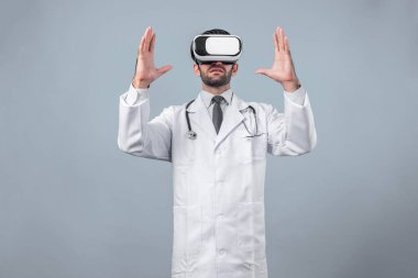 Kafkasyalı doktor metaevreni bağlamak için VR gözlük kullanırken tıbbi verilere bakıyor. Laboratuvar önlüğü ve görsel gerçeklik giyerken bir şeyi tutup işaret eden yetenekli bir doktor. Sapma.