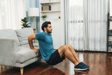 Atletik vücut ve aktif sporcu, sağlıklı vücut çalışma yaşam tarzı konsepti olarak neşeli ev egzersizlerinde kas kazanma egzersizi yapmak için mobilyaları kullanıyor..