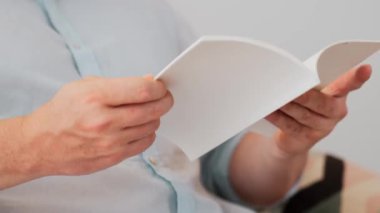 Kanepede oturan erkek, meslek büyümesi için ürün sunmak ya da iş değerini akıllı iş adamı olarak en yüksek noktaya çıkarmak için yaşam tarzı ve bilgi konseptine sahip bir defter ya da kitap hazırlar. Uyumsuzluk.