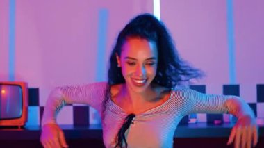 Stüdyoda mor ışıkla sokak dansı yapan İspanyol sokak dansçılarına yakın çekim. Profesyonel sanatçı şık kumaşla enerjik bir hareket sergiler. Çılgın, komik. Yarı vücut. Mutluluk.