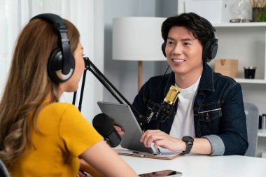 Gülümseyen radyo etkili sunucu elinde tablet, kulaklık takıyor kadın konuşmacı sosyal medya online canlı yayın kanalı ile röportaj yapıyor ve sabah stüdyo kaydında paylaşım linkini paylaşıyor. İnfobahn.