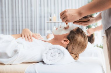 Kaplıca salonunun sakin atmosferi, modern gün ışığında lüks yüz kremi masajıyla gençleşmeye hevesli çiftler. Yüz bakımı ve güzellik konsepti. Sessiz.