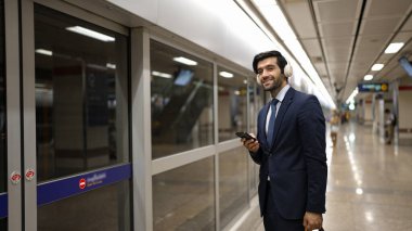 Proje yöneticisi tren istasyonunda şarkı seçmek için cep telefonu tutarken kulaklık takıyor. Zeki iş adamı bulanık bir geçmişi olan treni beklerken rahatlatıcı müzik dinliyor. Sevinçli..
