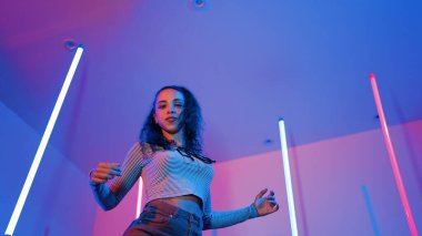 Latin dansçıların kameraya bakıp şehrin pop müziğiyle dans ettiği düşük açılı kamera. Profesyonel çekici hipster, mor veya neon ışıklı hip hop şarkısına geçiyor. Şık bir kumaş. Mutluluk.