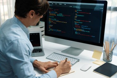 Stresli bilişim geliştiricisi deneme uygulamasında kodlama programı olan bilgisayar ve bilgisayar üzerinde çevrimiçi yazılım geliştirme bilgilerini analiz ediyor. Teknik mühendis önemli not listeleri yazıyor. Bireysel.