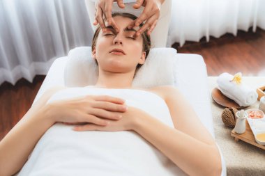 Kafkasyalı kadın stres önleyici kafa masajından ve lüks tatil beldesi ya da otel spa salonundaki modern ışık ortamında yüz güzelliği eğlencelerini şımartmaktan hoşlanıyor. Sessiz.