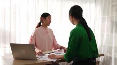 Yavaş çekim iki tasarımcı beyin fırtınası yapıyor ve grafik tasarımı için renk seçiyor ya da istemci renk bozukluklarını tasarımcı bürosundaki kromatik konsültasyonla karşılaştırıyor. Değiştirilmiş