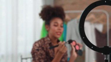 Kadın nüfuzlu kişi canlı yayında video görüntülerini çekiyor. Makyaj çok önemli sosyal medya ya da blog. Kozmetik stüdyosu ışıklandırmalı mutlu genç kız çevrimiçi pazarlama oturumu yayını için..