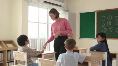 Sınıfta çeşitli çocuklar sınıf ödevlerini yaparken, Kafkasyalı öğretmen sınıfta yürüyor ve öğrenci ödevlerini kontrol ediyor. Çeşitli zeki öğrenciler ilkokulda ders veriyor ve not alıyor. Pedagoji.