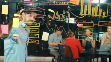 Cam duvarda istatistiksel mali grafiği olan pazarlama stratejisini işaret eden yetenekli bir işadamı. Profesyonel iş ekibi sunumu dinlerken müdür pazarlama fikrini paylaşıyor. İzleme