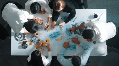 Türbin motoru tasarlamak için çalışan akıllı mühendis takımının yukarıdan aşağıya hava görüntüsü. Profesyonel teknisyen jet motoru yapımını tartışırken motorun bir kısmını işaret ediyor. Hizalama.