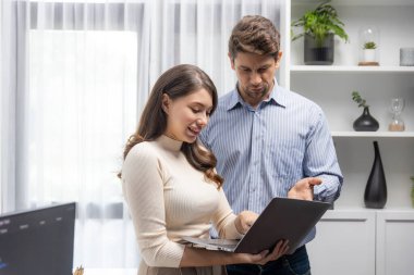 Güzel bir kadın dizüstü bilgisayarını elinde tutuyor. Zeki bir iş arkadaşıyla çalışıyor. Rapor analizi işi üzerinde çalışıyor. Varsayım.