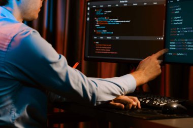 Uygulama pc ekranları ile çevrili çevrimiçi yazılım geliştirme bilgilerini yoğunlaştıran IT geliştiricisi, neon modern ofis evindeki web sitesinde yazılım için program yaratıyor. Toplayıcı.