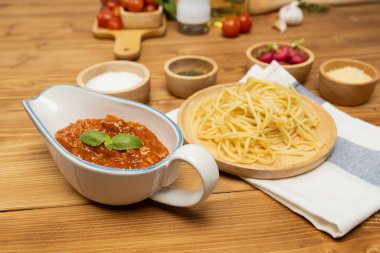 Lezzetli yiyecekler, ev yapımı spagetti, kıymalı domates sosu ve fesleğen fırlatma elementleri, şef masası dekoratif baharatlarla servis ediliyor. Varsayım.