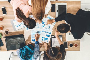 Modern ofisteki iş adamları ve iş kadınlarıyla grup toplantısındaki iş adamlarının en üst düzey görüşü, masada dizüstü bilgisayar, kahve ve belge ile. Kurumsal şirketler uds