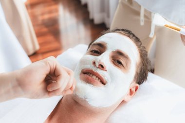 Kaplıca salonunun sakin atmosferi, insan müşterisi modern gün ışığında lüks yüz kremi masajıyla kendini yenileme zevkine kapılıyor. Yüz bakımı ve güzellik konsepti. Sessiz.