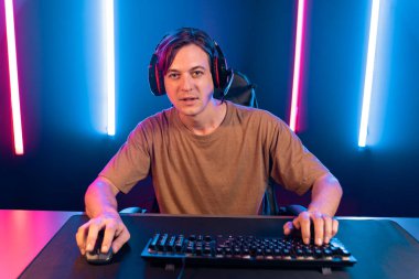 Kazanmak için çevrimiçi oyun oynayan akıllı flama makinesinin sunucu kanalı, neon ışıklı odada seçilen takım yarışması için izleyicilerle birlikte canlı yayında canlı yayında kulaklık takıyor. Bireysel.