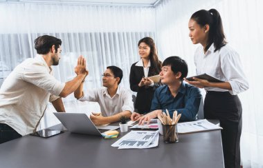 Çeşitli ofis çalışanlarından oluşan bir grup, stratejik iş pazarlama planlaması konusunda anlaşma yaptıktan sonra beşlik çaktı. Takım çalışması ve olumlu tutum verimli ve destekleyici bir iş yeri yaratır. Tedbirli