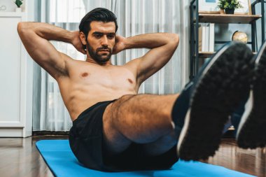 Atletik ve sporcu adam, evde vücut egzersizi yaparken spor ve spor yaşam tarzına uyum sağlamak için spor minderinde çatırdıyor. Gaiety ev egzersizi antrenman konsepti.