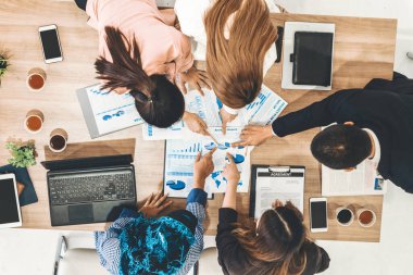 Modern ofisteki iş adamları ve iş kadınlarıyla grup toplantısındaki iş adamlarının en üst düzey görüşü, masada dizüstü bilgisayar, kahve ve belge ile. Kurumsal şirketler uds