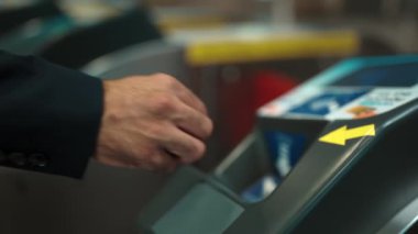 Çok kültürlü yolcuların elleri turnikelere madeni para koydu ve içeri girmek için gökyüzü treni, metro gibi insanlarla çevrili toplu taşıma araçlarını kullandı. Çalışma rutini. Sevinçli..