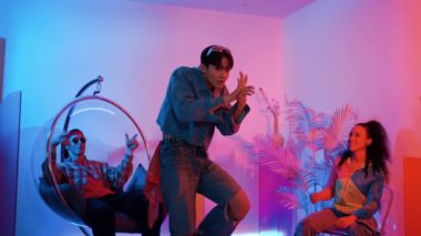 Çok kültürlü bir arkadaş kürsüde otururken Asyalı yetenekli bir dansçı modern müziğe geçiyor. Profesyonel dansçı, hipster takımı tezahürat yaparken ve desteklerken enerjik adımlar atıyor. Mutluluk.