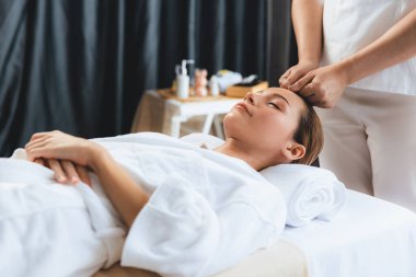 Kafkasyalı kadın stres önleyici kafa masajından ve lüks tatil beldesi ya da otel spa salonundaki modern ışık ortamında yüz güzelliği eğlencelerini şımartmaktan hoşlanıyor. Sessiz.